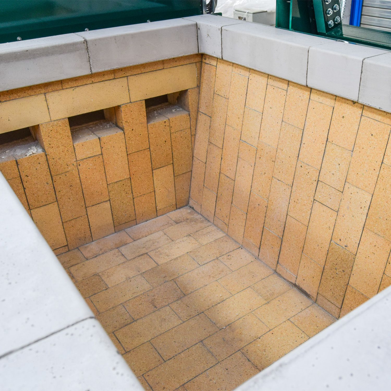 Inside the primary chamber: interlocking firebrick, and the pre-cast block rim that takes the impact of loading.