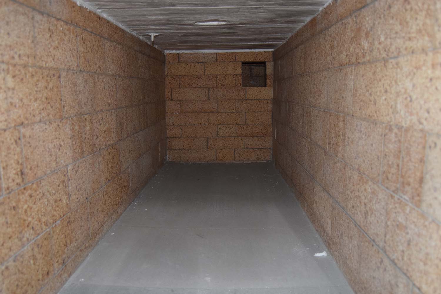 Inside the primary chamber, looking in through the front door: firebrick on all faces, with the burner port in the rear wall.