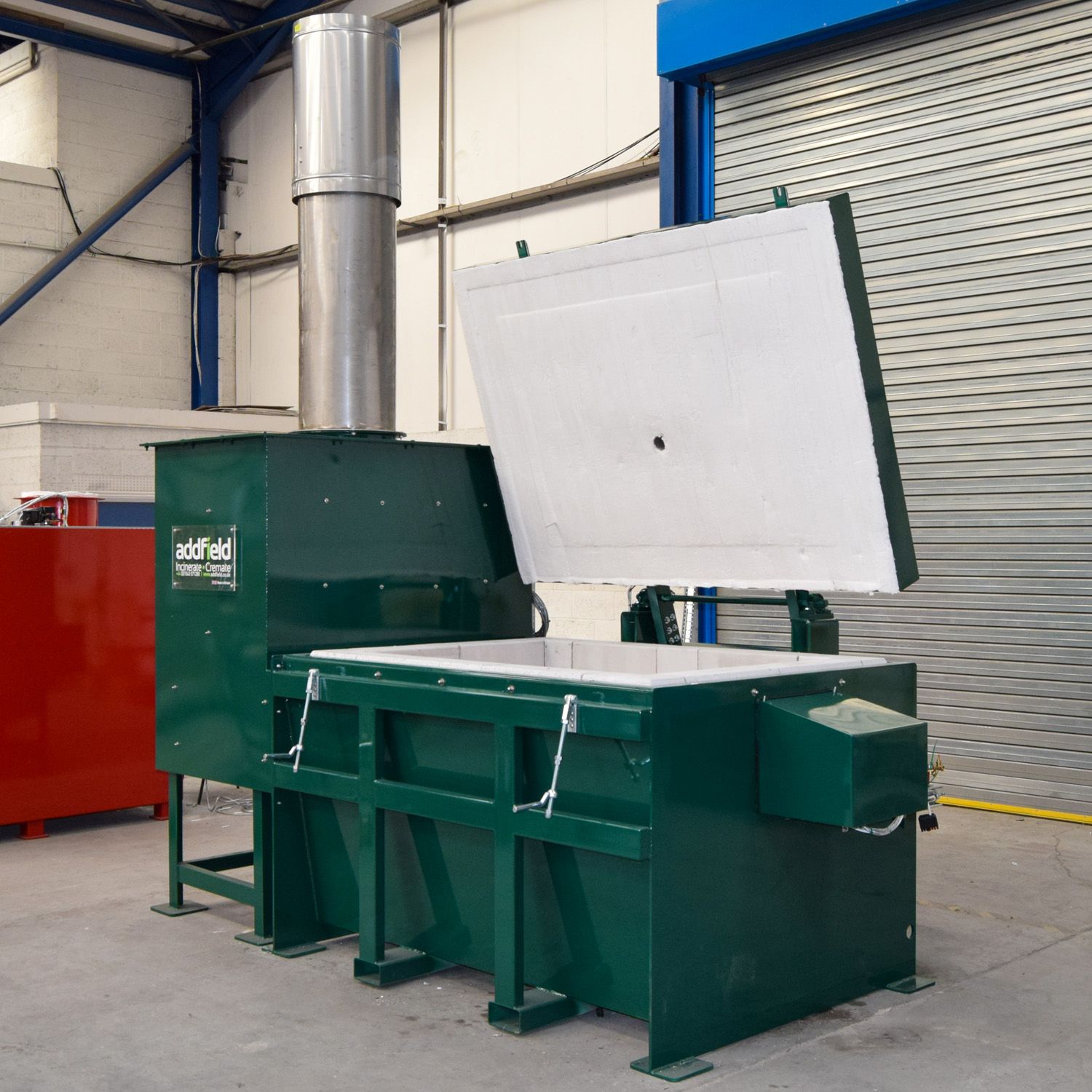 The counterbalanced lid raised, showing the refractory fibre insulation on its underside.