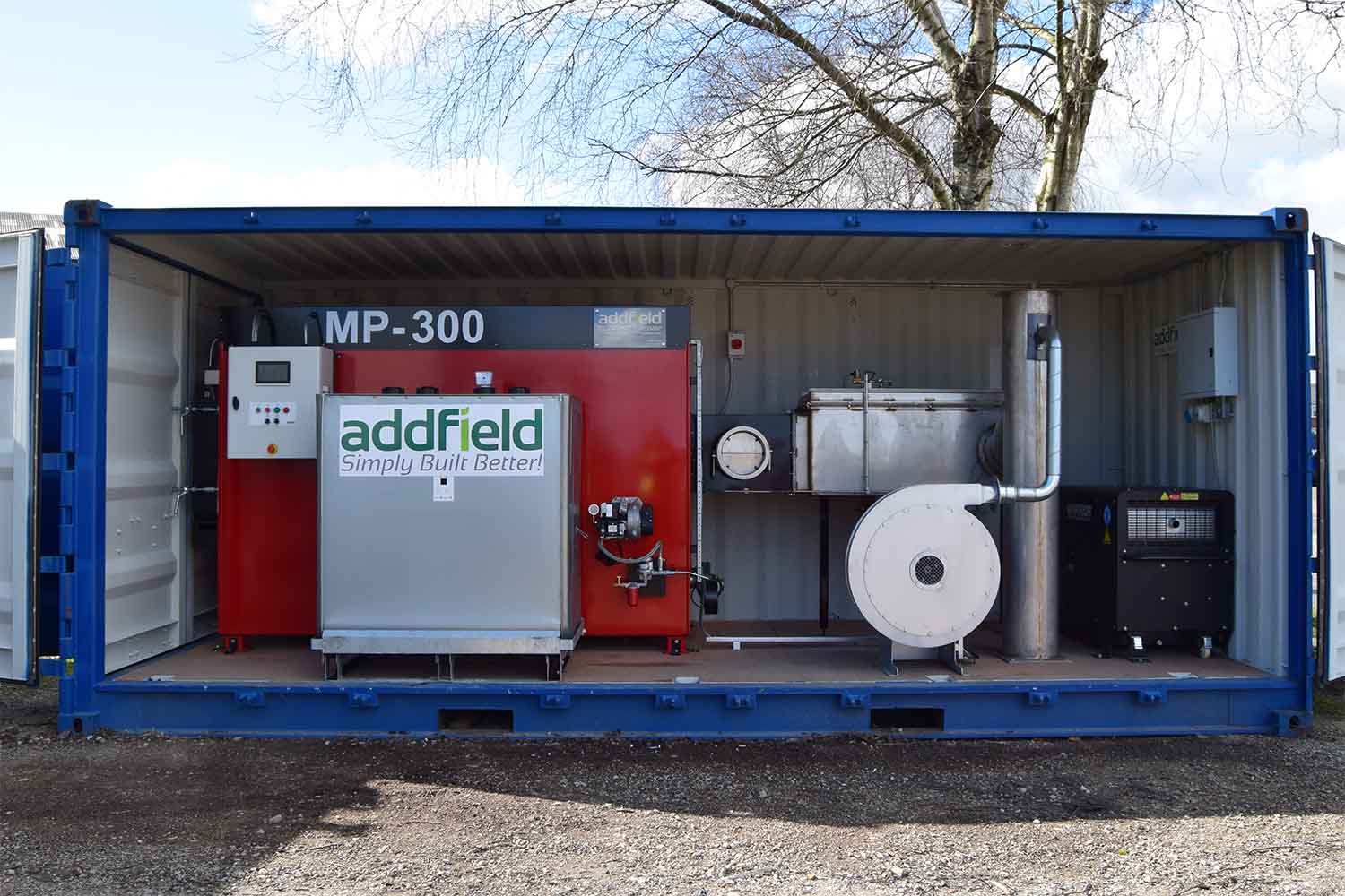 An MP300 built into a shipping container with its wet scrubber, extraction fan, control panel and generator — the form in which a machine reaches an island.